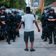 A man talks to police in riot gear as they wait in an alley after a second night of clashes between protesters and police Aug. 15, 2016, in Milwaukee.
Darren Hauck/Getty Images